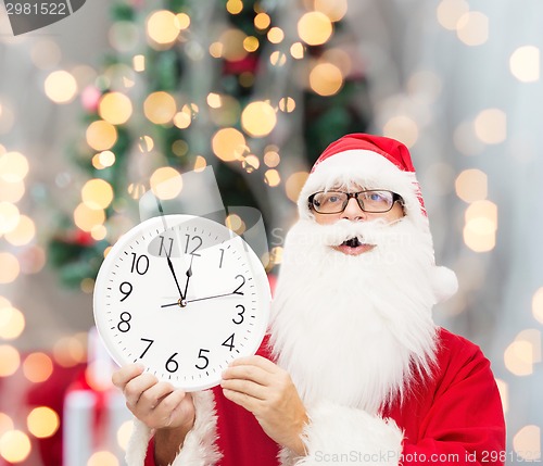 Image of man in costume of santa claus with clock