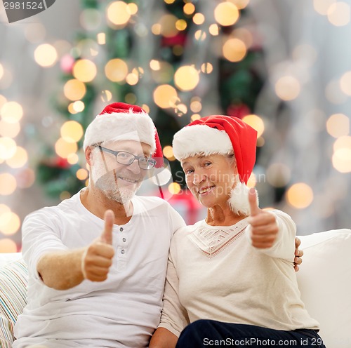 Image of happy senior couple in santa helper hats