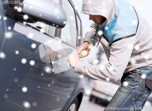 Image of thief breaking car lock with screwdriver