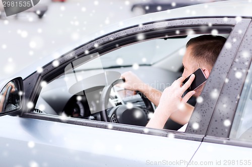 Image of close up of man using smartphone while driving car