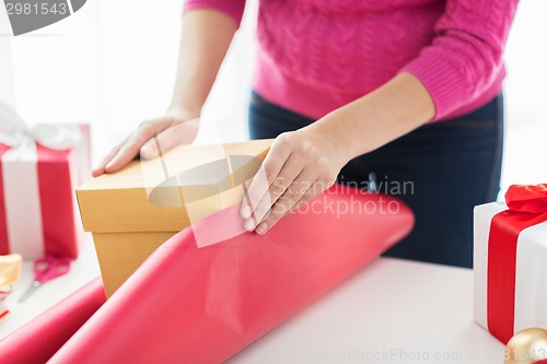 Image of close up of woman decorating christmas presents