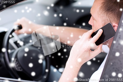 Image of close up of man using smartphone while driving car