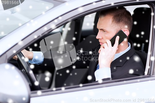 Image of close up of man using smartphone while driving car