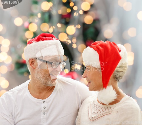 Image of happy senior couple in santa helper hats