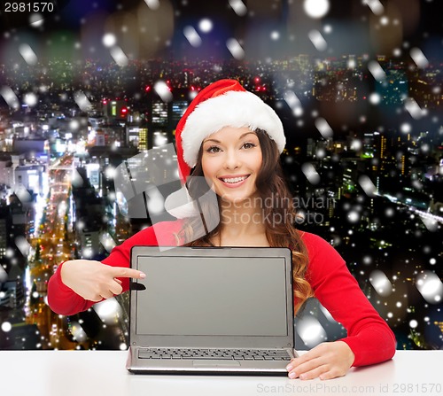 Image of smiling woman in santa helper hat with laptop