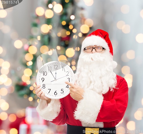 Image of man in costume of santa claus with clock