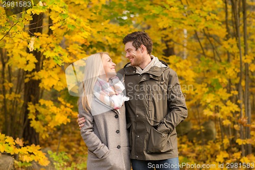 Image of smiling couple hugging in autumn park