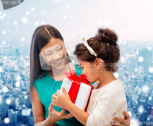 Image of happy mother and little girl with gift box