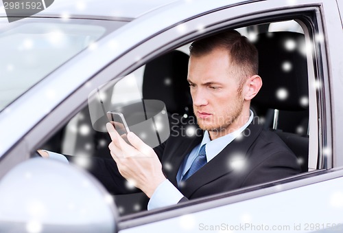 Image of close up of man using smartphone while driving car