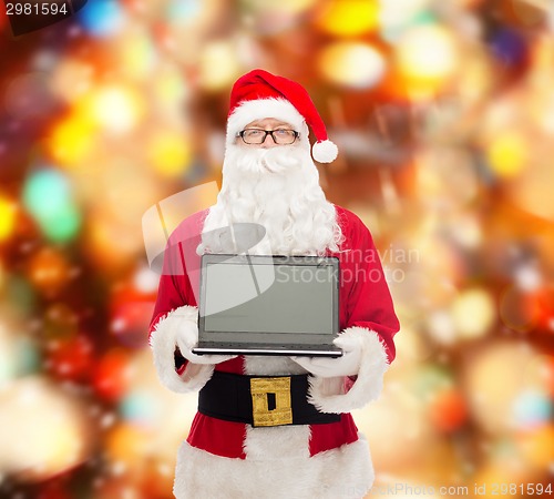 Image of man in costume of santa claus with laptop