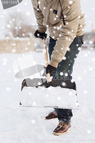 Image of closeup of man digging snow with shovel