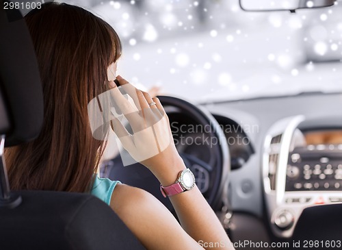 Image of close up of woman with smartphone driving car