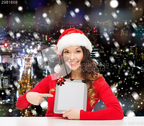 Image of smiling woman in santa hat with gift and tablet pc