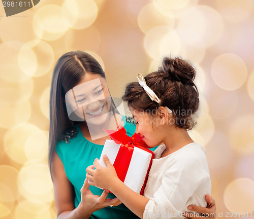 Image of happy mother and little girl with gift box