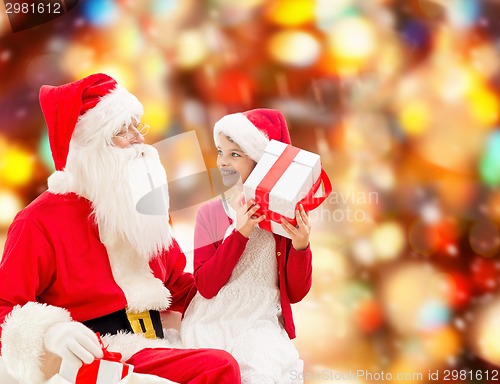 Image of smiling little girl with santa claus and gifts