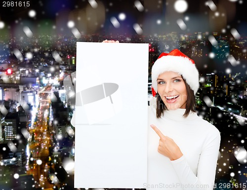 Image of smiling young woman in santa hat with white board