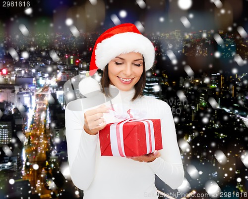 Image of smiling woman in santa helper hat with gift box