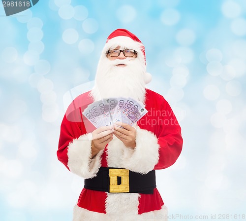 Image of man in costume of santa claus with euro money