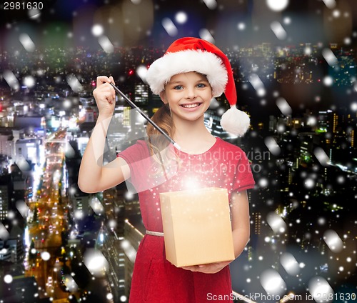 Image of smiling girl in santa helper hat with gift box