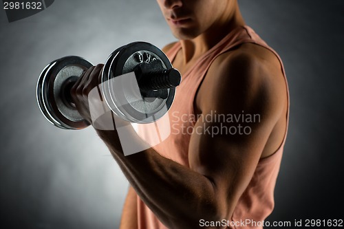 Image of close up of young man with dumbbell