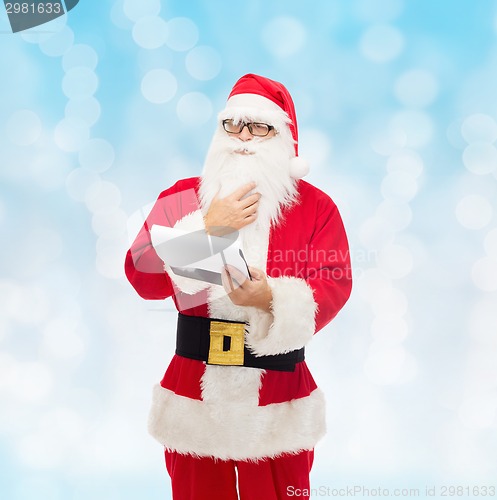 Image of man in costume of santa claus with notepad