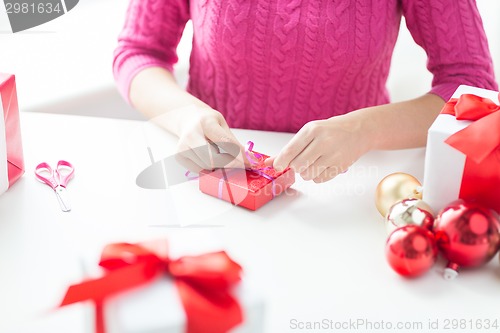 Image of close up of woman decorating christmas presents