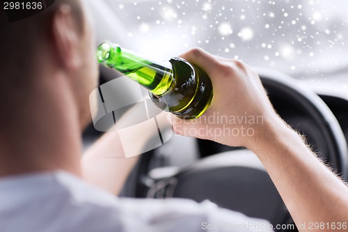 Image of close up of man drinking alcohol while driving car