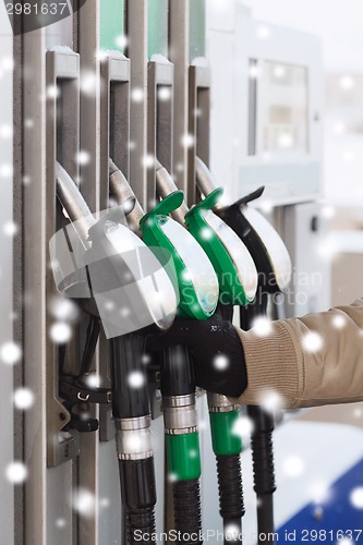 Image of close up of man with fuel hoses at gas station