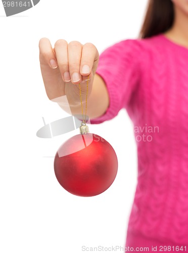 Image of close up of woman in sweater with christmas ball