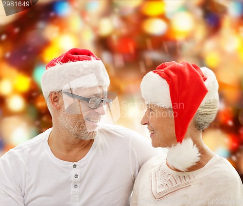 Image of happy senior couple in santa helper hats