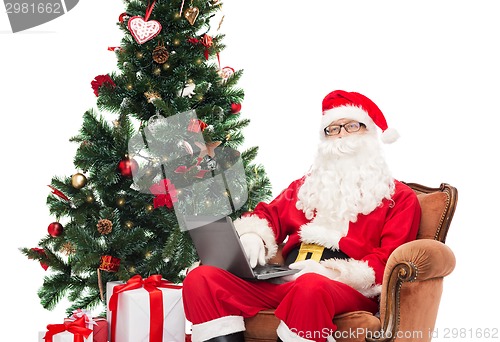 Image of man in costume of santa claus with laptop