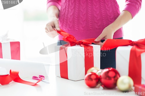 Image of close up of woman decorating christmas presents