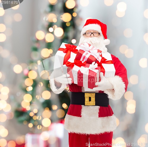 Image of man in costume of santa claus with gift boxes