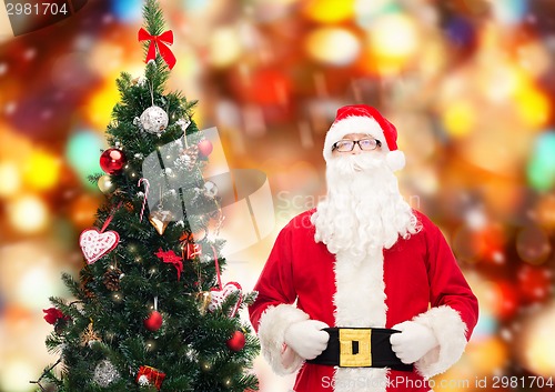 Image of man in costume of santa claus with christmas tree