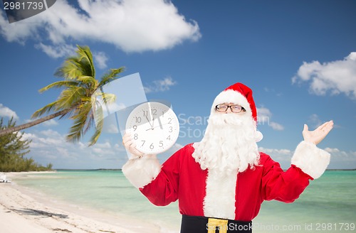 Image of man in costume of santa claus with clock