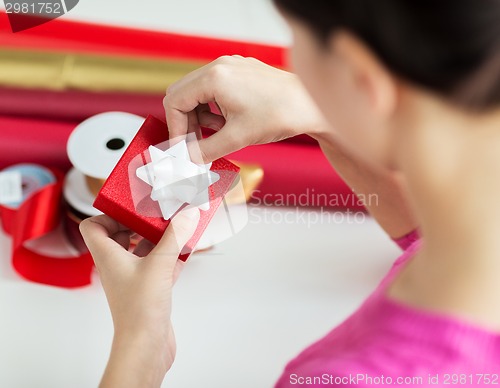 Image of close up of woman decorating christmas presents