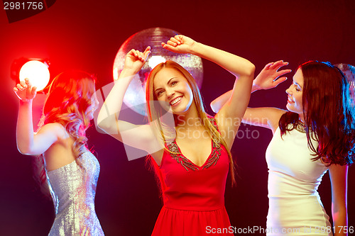 Image of three smiling women dancing in the club