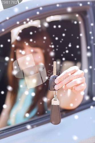 Image of close up of smiling woman with car key outdoors