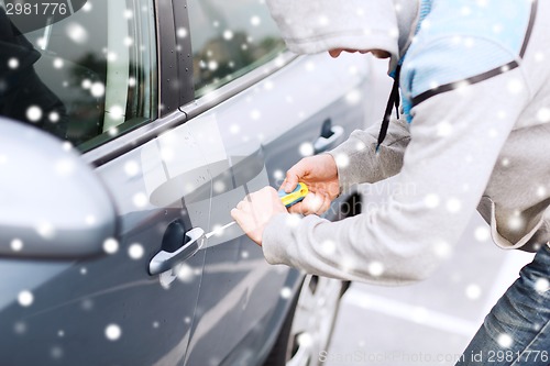 Image of thief breaking car lock with screwdriver