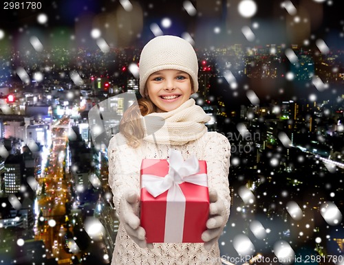 Image of dreaming girl in winter clothes with gift box
