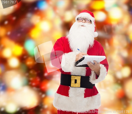 Image of man in costume of santa claus with notepad