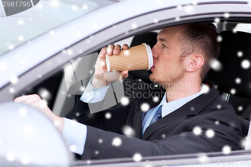 Image of close up of man drinking coffee while driving car