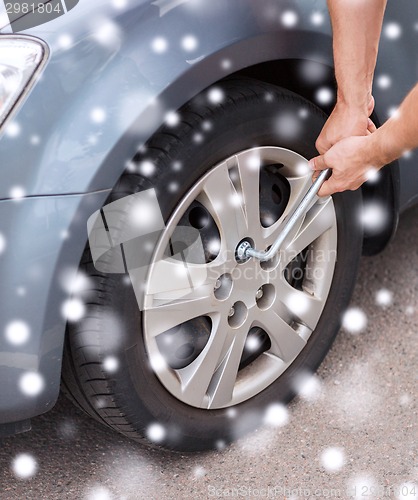 Image of man changing tire