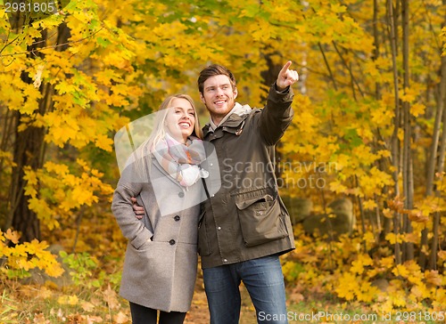 Image of smiling couple hugging in autumn park