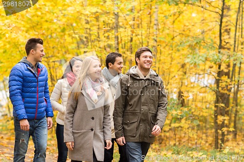 Image of group of smiling men and women in autumn park