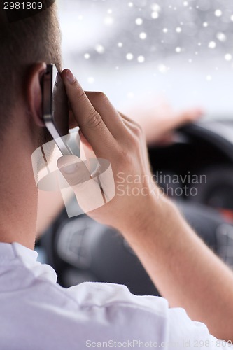 Image of close up of man using smartphone while driving car