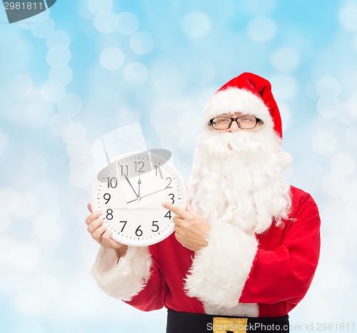 Image of man in costume of santa claus with clock