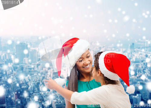 Image of happy mother and girl in santa hats