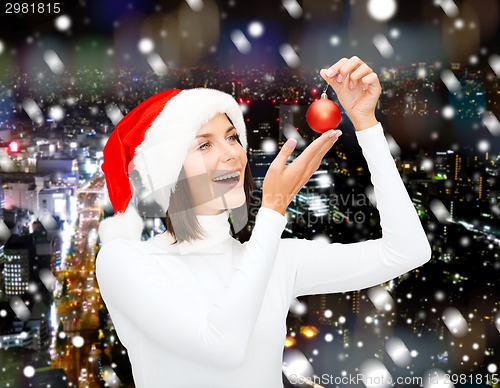 Image of woman in santa helper hat with christmas ball