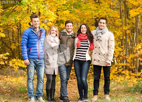 Image of group of smiling men and women in autumn park